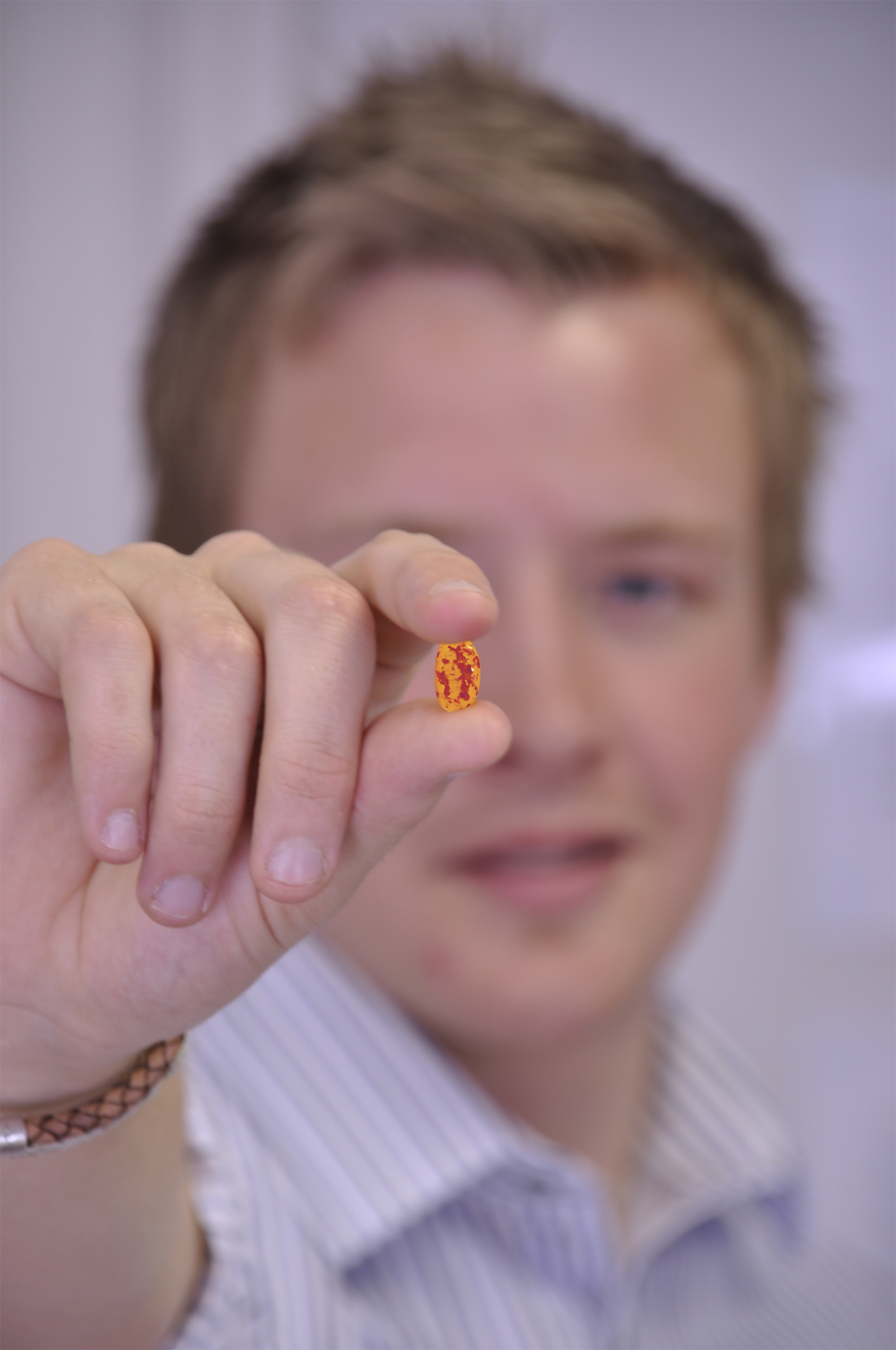 A man holding a jelly bean with the face of Kate Middleton on it